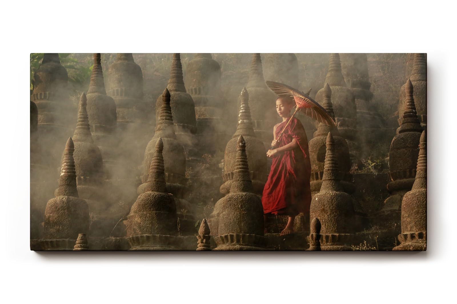 Sinus Art Wandbild 120x80cm Junger Mönch mit Schirm zwischen alten Stupas – Symbol für Glaube und Einkehr