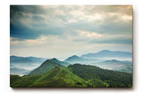 Sinus Art Wandbild 120x80cm Weite grüne Hügel und Berge unter wolkenverhangenem Himmel mit Lichteinfall