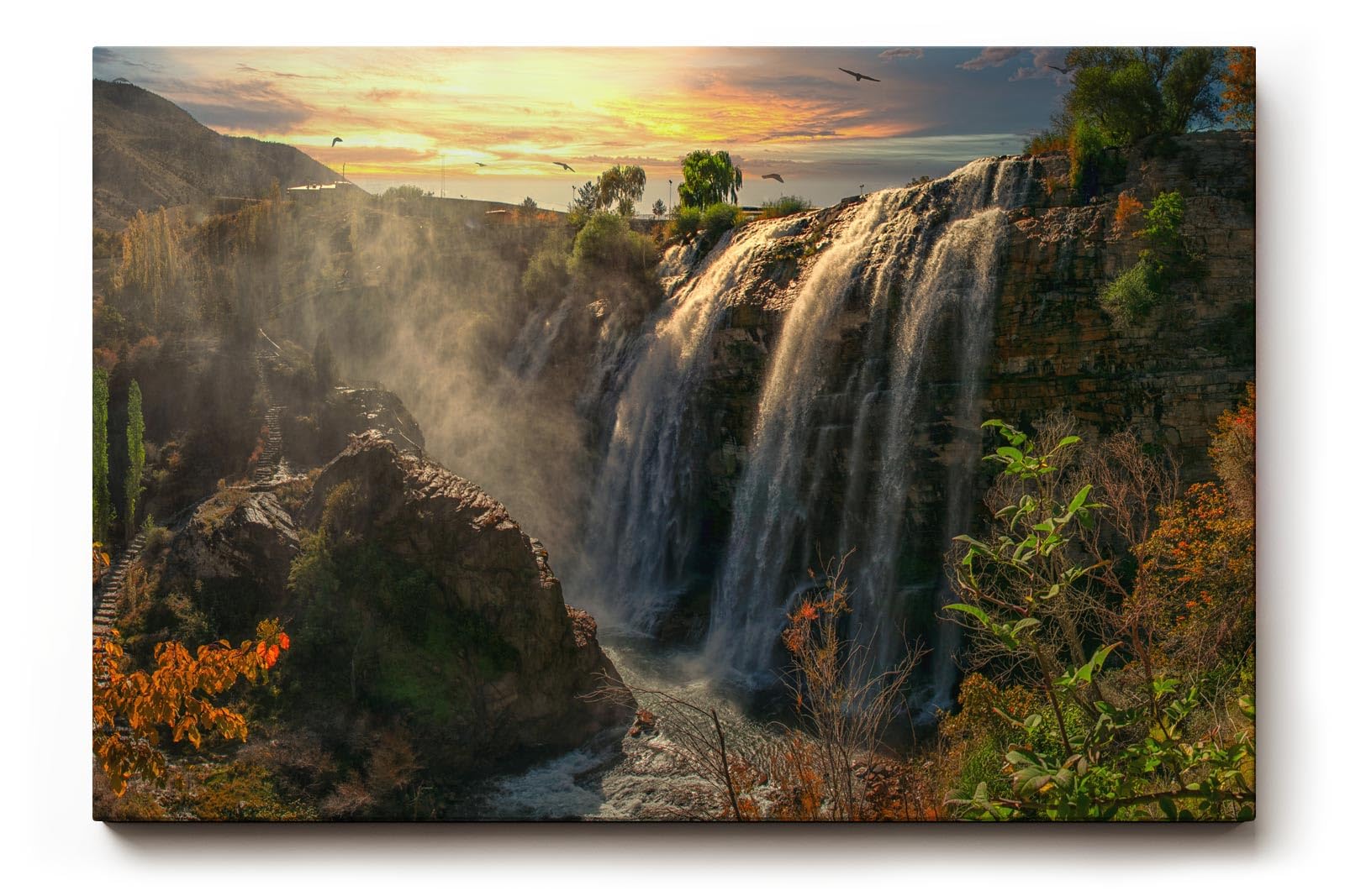 Sinus Art Wandbild 120x80cm Wasserfall-Szenerie im warmen Licht des Sonnenuntergangs mit lebendiger Vegetation