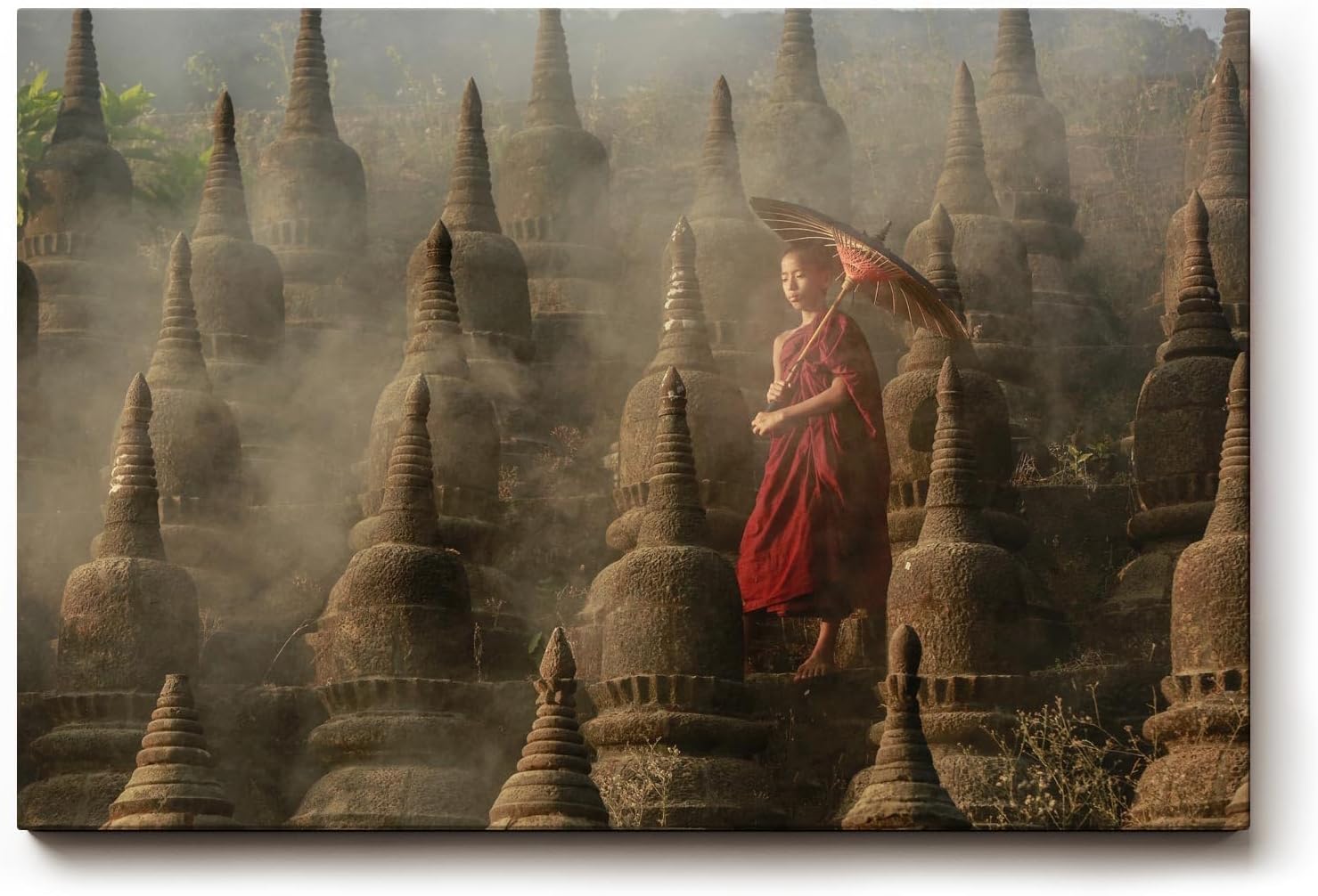 Sinus Art Wandbild 120x80cm Junger Mönch mit Schirm zwischen alten Stupas – Symbol für Glaube und Einkehr