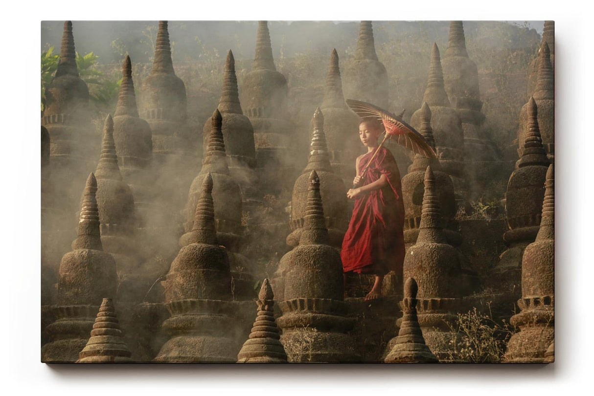 Sinus Art Wandbild 120x80cm Junger Mönch mit Schirm zwischen alten Stupas – Symbol für Glaube und Einkehr