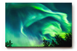 Sinus Art Wandbild 120x80cm Atemberaubende Aurora Borealis mit dynamischem Farbspiel über Silhouetten dunkler Bäume