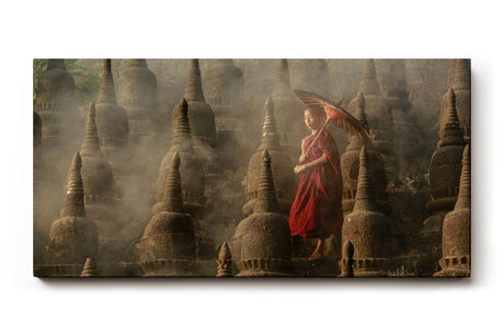 Sinus Art Wandbild 120x80cm Junger Mönch mit Schirm zwischen alten Stupas – Symbol für Glaube und Einkehr