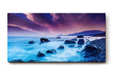 Sinus Art Wandbild 120x80cm Mystische Felsenküste bei Nacht unter violettem Himmel mit leuchtendem Wasser