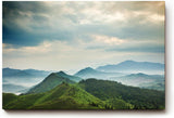 Sinus Art Wandbild 120x80cm Weite grüne Hügel und Berge unter wolkenverhangenem Himmel mit Lichteinfall