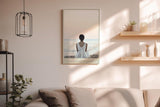 Paul Sinus Wandbild in 40x60cm Waiting for the Horizon – Frau in weißem Kleid am Strand mit Blick auf das Meer bei sanftem Sonnenuntergang