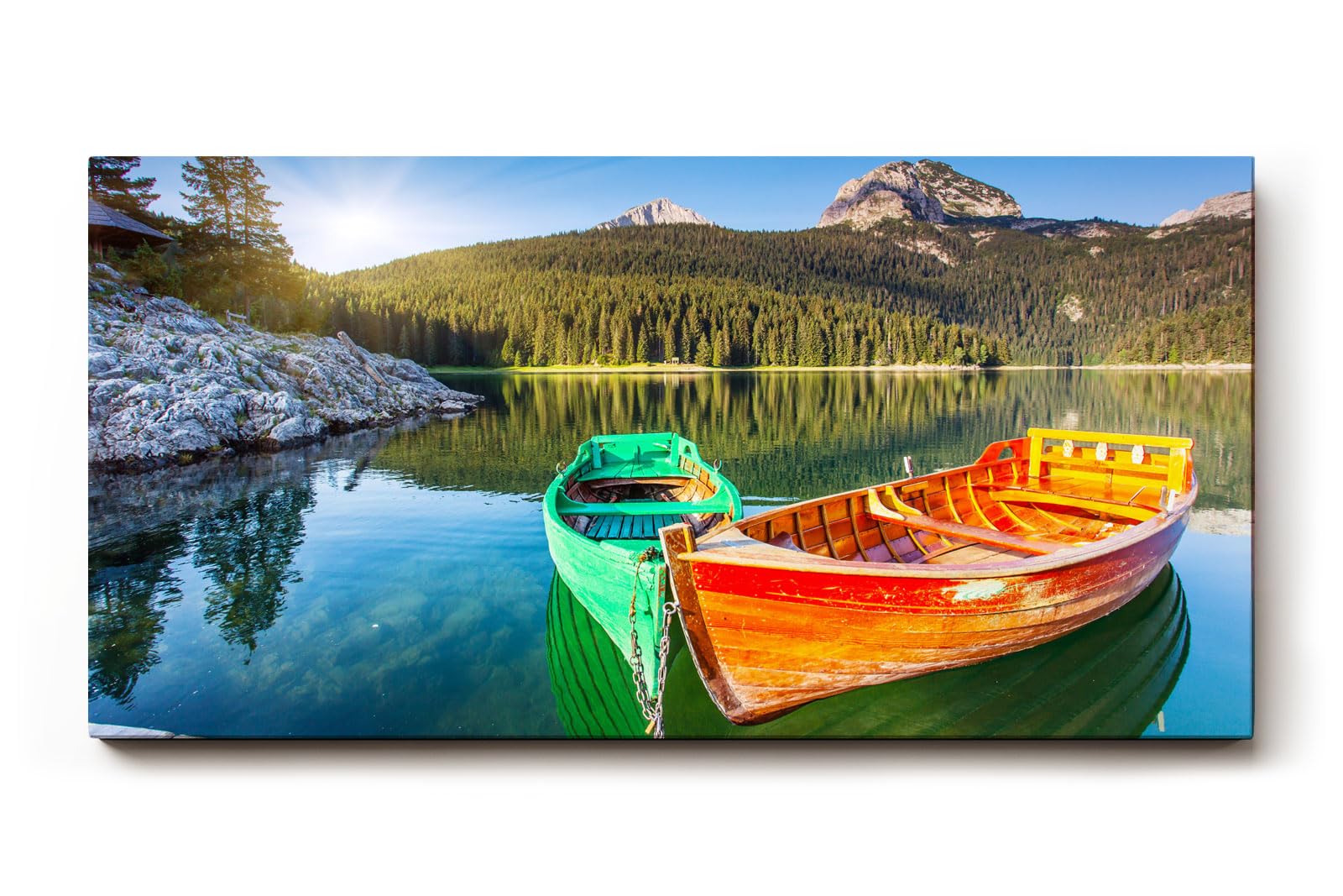 Sinus Art Wandbild 120x80cm Farbkräftige Boote auf spiegelndem Wasser mit Wald und Bergen im Hintergrund