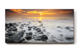 Sinus Art Wandbild 120x80cm Ruhiges Küstenmotiv mit Felsen im Wasser und goldenem Sonnenuntergang