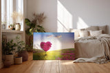 Sinus Art Wandbild 120x80cm Herzförmiger Baum in pinker Blüte in weiter Frühlingslandschaft mit Blumenwiese
