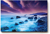 Sinus Art Wandbild 120x80cm Mystische Felsenküste bei Nacht unter violettem Himmel mit leuchtendem Wasser