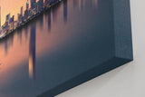 Sinus Art Wandbild 120x80cm Städtische Skyline in der Dämmerung mit reflektierendem Wasser und ruhigem Boot – kontrastreich und elegant