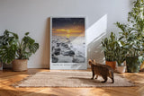 Paul Sinus Kunstdruck 40x60cm Path of Stillness – Sonnenuntergang über ruhiger Küste mit dunklen Steinen im Wasser