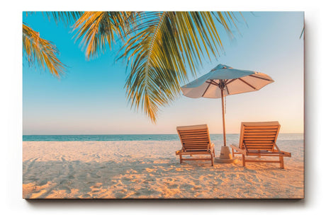 Sinus Art Wandbild 120x80cm Zwei Sonnenliegen am Palmenstrand mit Schirm vor blauem Himmel für entspannte Wirkung