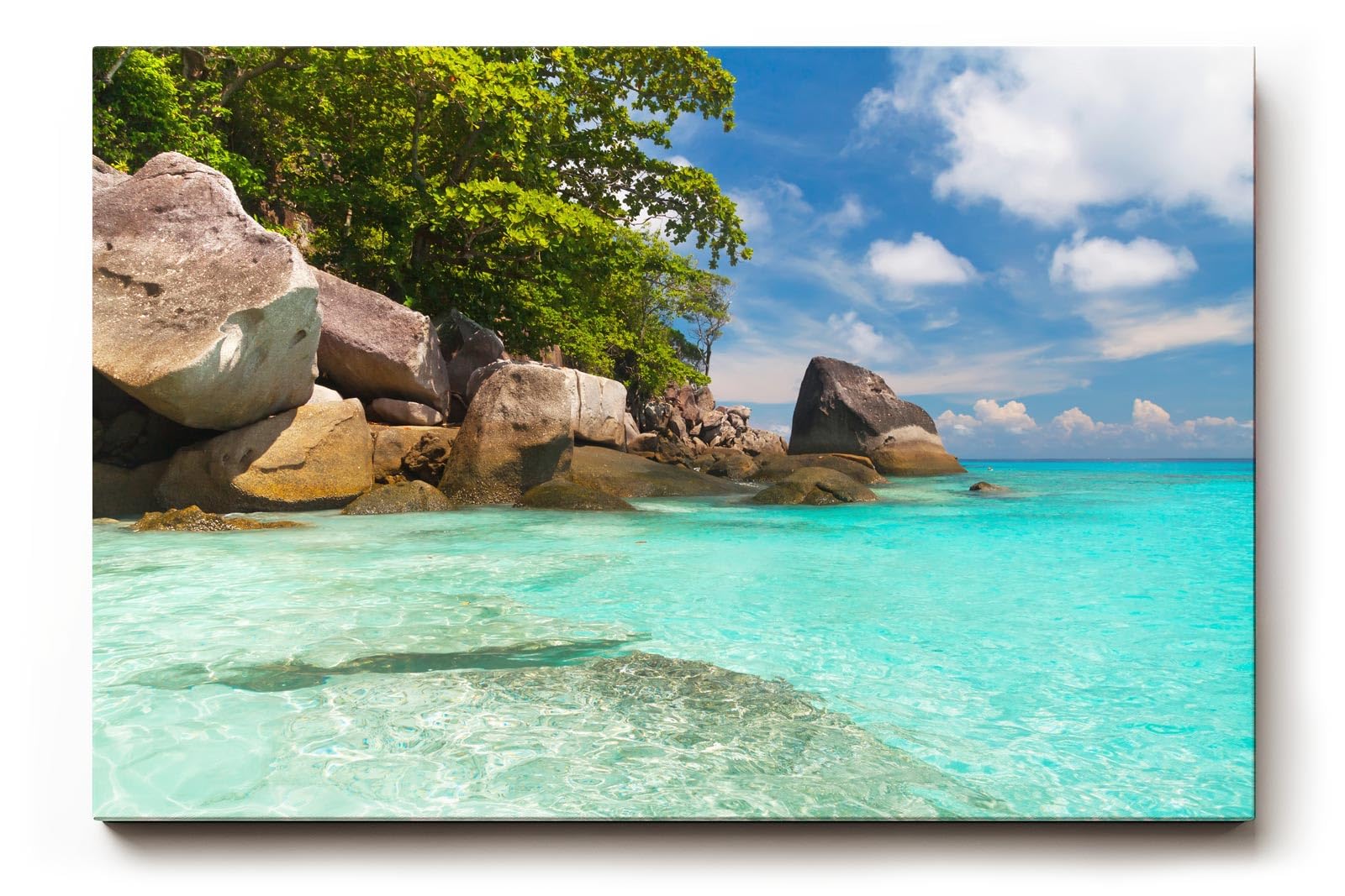 Sinus Art Wandbild 120x80cm Feinsandiger Strand mit Felsen und türkisfarbenem Wasser – paradiesisch und entspannend