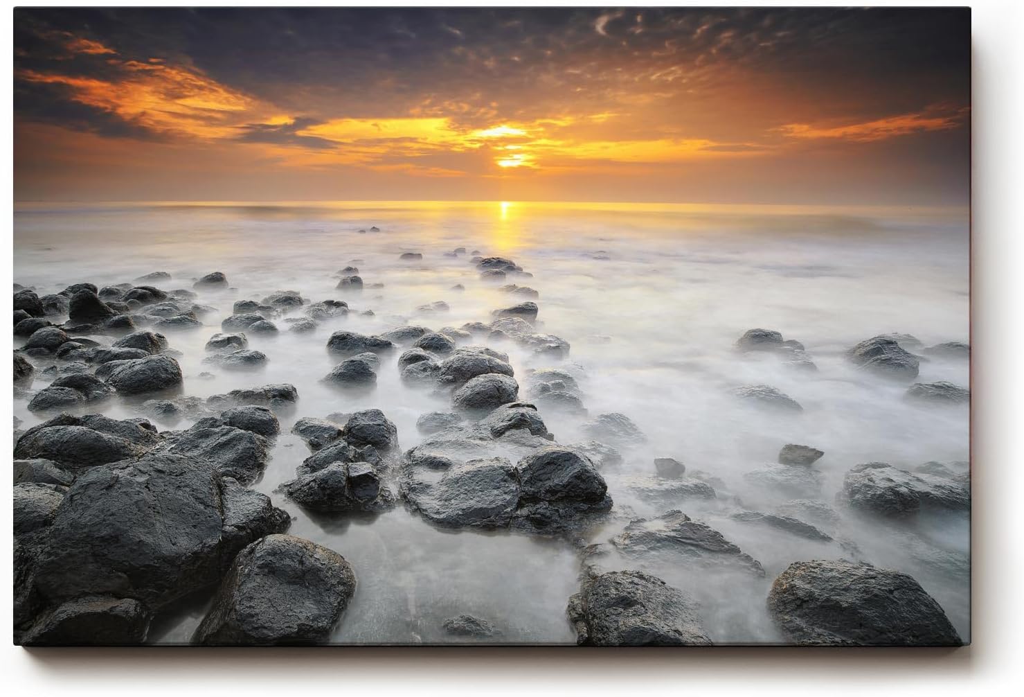 Sinus Art Wandbild 120x80cm Ruhiges Küstenmotiv mit Felsen im Wasser und goldenem Sonnenuntergang
