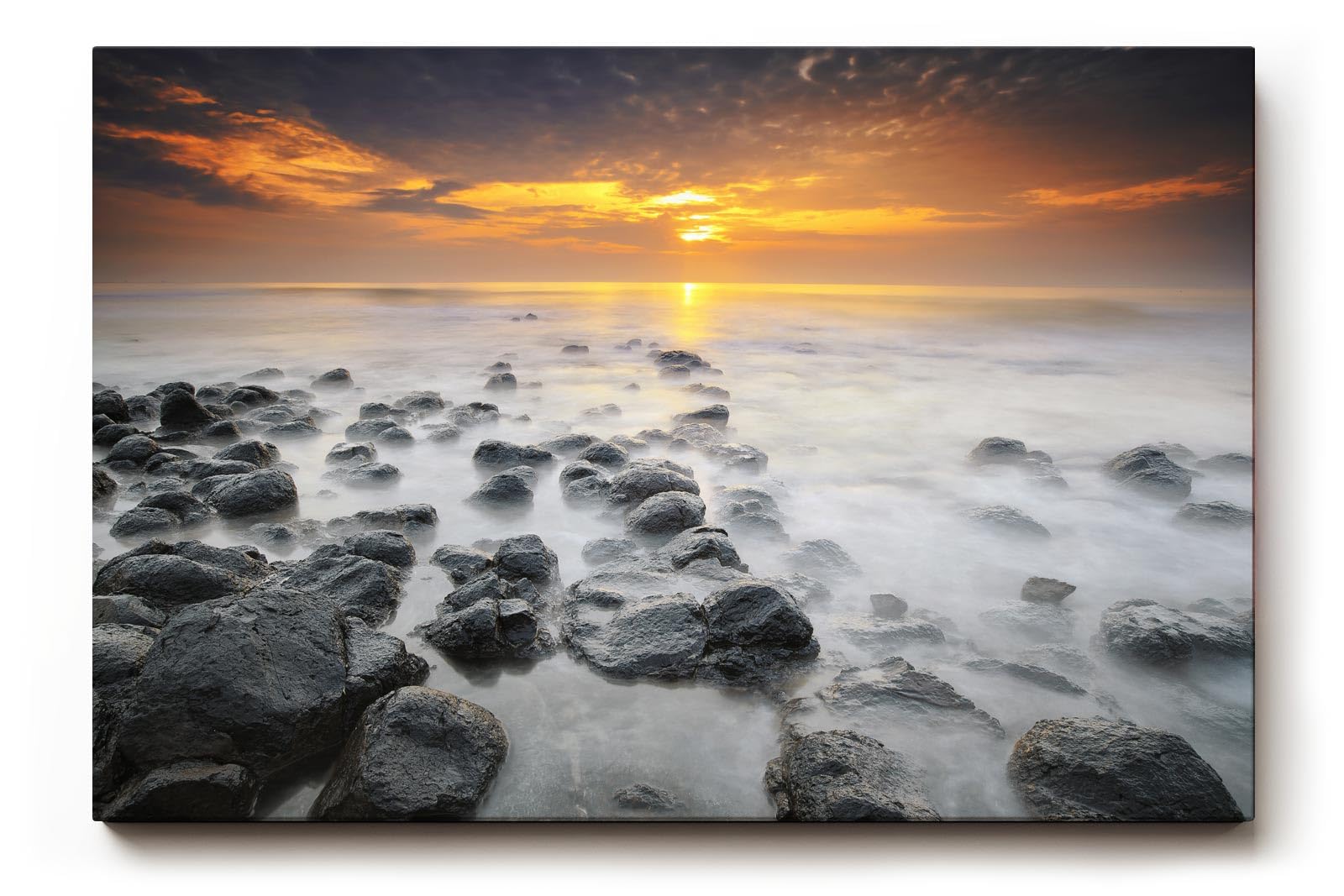 Sinus Art Wandbild 120x80cm Ruhiges Küstenmotiv mit Felsen im Wasser und goldenem Sonnenuntergang