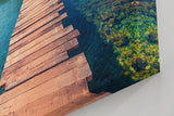 Sinus Art Wandbild 120x80cm Holzsteg führt zur Insel im klaren Meer – Symbol für Freiheit und Fernweh