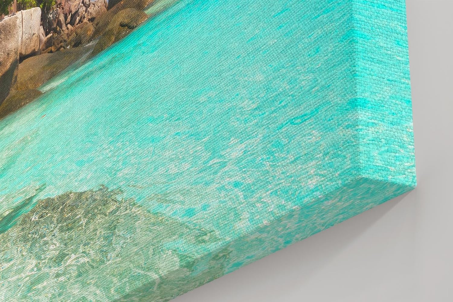 Sinus Art Wandbild 120x80cm Feinsandiger Strand mit Felsen und türkisfarbenem Wasser – paradiesisch und entspannend