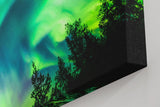 Sinus Art Wandbild 120x80cm Atemberaubende Aurora Borealis mit dynamischem Farbspiel über Silhouetten dunkler Bäume
