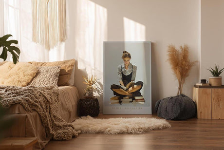 Paul Sinus Wandbild in 40x60cm In Her Own Chapter – Ausdrucksstarkes Porträt einer jungen Frau, auf Bücherstapeln sitzend und lesend, moderne Bilder mit klaren Linien und warmen Akzenten