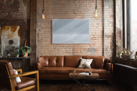 Paul Sinus Wandbild The Lonely Reindeer Journey – Minimalistische Winterlandschaft mit einsamem Rentier auf weiter Schneefläche, Symbol für Stille und Ausdauer