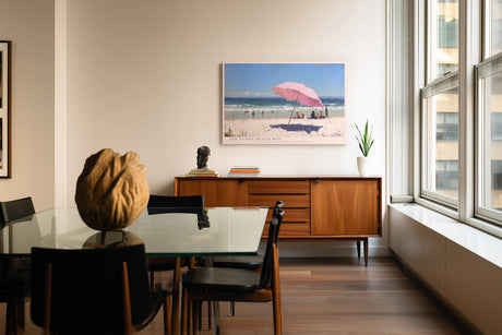 Paul Sinus Wandbild The Sunny Beach Day Impressionistisches Strandmotiv mit rosa Sonnenschirm, blauen Wellen und entspannter Urlaubsstimmung.