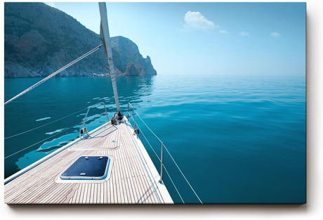 Sinus Art Wandbild 120x80cm Ruhiger Ausblick von einem Segelboot über das glitzernde Wasser zur felsigen Küste